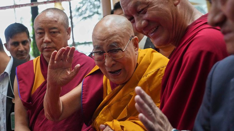 The Dalai Lama, centre, greets people as he arrives at an event a day before his 90th birthday. Pic: AP/Ashwini Bhatia