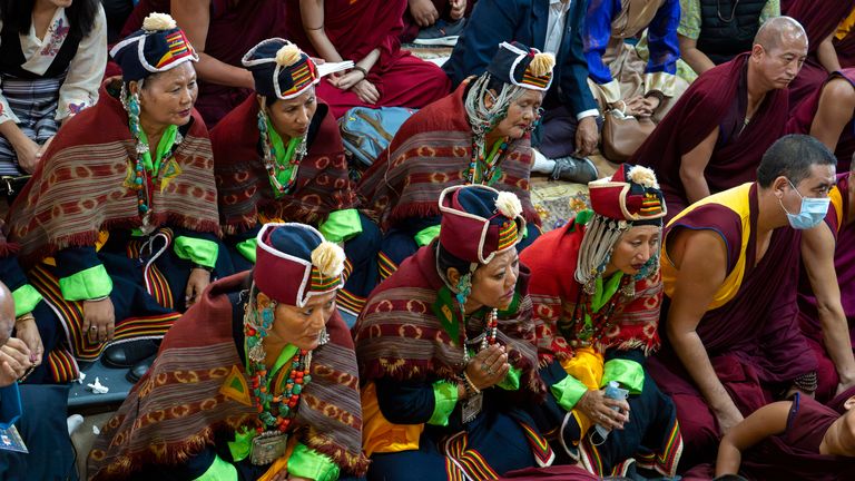 Devotees watch Tibetan spiritual leader the Dalai Lama on a tv screen at an event on Saturday. Pic: AP/Ashwini Bhatia