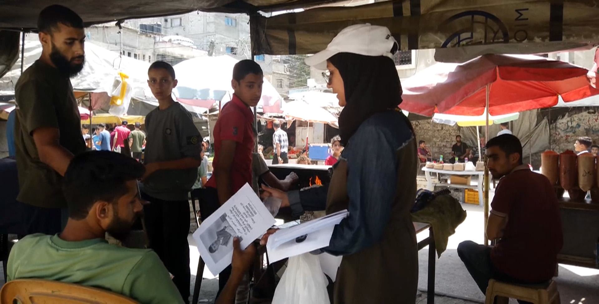 Anwar Hawas shows her missing brother’s photograph to people in the streets of Gaza, asking if they have any information about his whereabouts. Anwar Hawas shows her missing brother’s photograph to people in the streets of Gaza, asking if they have any information about his whereabouts.
